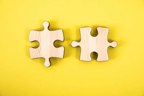 Sarı arka planda bir yapbozun iki parçası