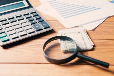 Konsept araştırma maliyetleri. Masanın üzerinde hesap makinesi, istatistik ve büyüteç