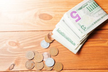 Dolar banknotları ve madeni paralar masada.