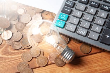 İş fikri konsepti. Hesap makinesinin yanında madeni paralar ve masanın üzerinde bir lamba.