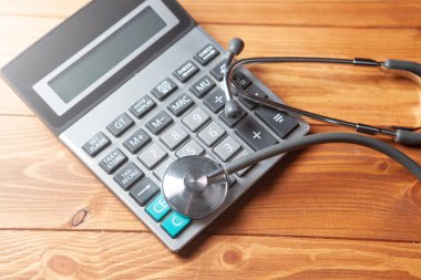 gray stethoscope on the calculator on the table
