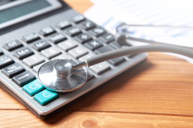 gray stethoscope on the calculator on the table