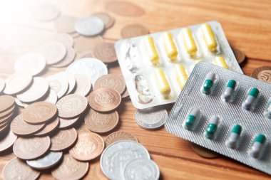 money and pills on a wooden table
