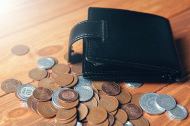 wallet and coins on a wooden table