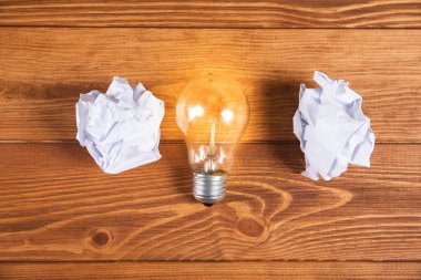 bundle of paper and lamp on wooden background