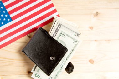 america flag, dollars and wallet on wooden background