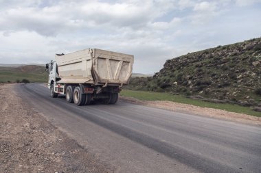 Büyük beyaz çöp kamyonu otoyolda.