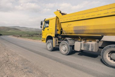Büyük sarı damperli kamyon otoyolda