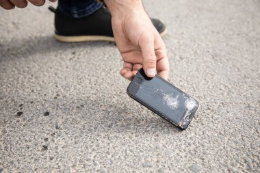 Adamın biri bozuk bir telefonu kaldırıyor.