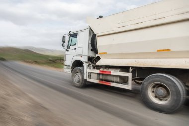 Büyük beyaz çöp kamyonu otoyolda.