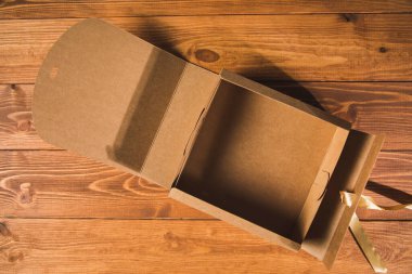 Masadaki kahverengi hediye kutusunu aç.