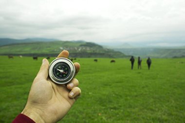 Gün boyunca yeşil bir alanın arka planında pusula