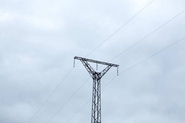 Akşamları bulutların altında yüksek voltajlı elektrik kuleleri