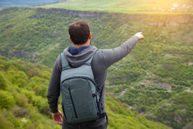 Uçurumun kenarındaki adam eliyle işaret eder.