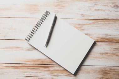 Kalem ve defter ahşap masada.