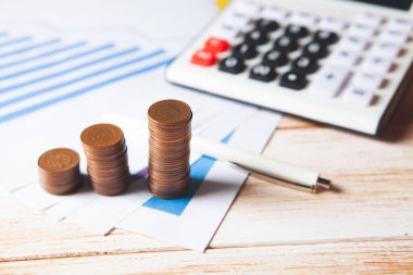Tahta bir tablo hesap makinesi, madeni para ve istatistik üzerinde