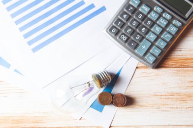 İş fikri konsepti. Hesap makinesinin yanında madeni paralar ve masanın üzerinde bir lamba.