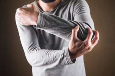 Adam dirseğini tuttu. eklem ağrısı