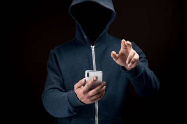 Telefonu koyu bir arkaplanda tutarken sanal ekrana tıklıyor. hacker konsepti