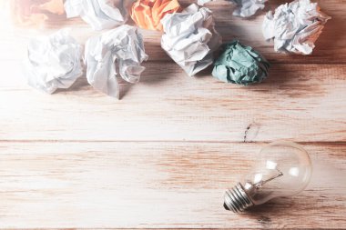 Bir tomar kağıt ve masada bir ampul.