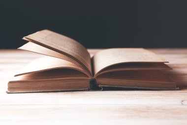Tahta bir masanın üzerinde açık bir kitap