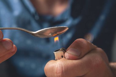 Bağımlı kaşığı pudrayla ısıtır