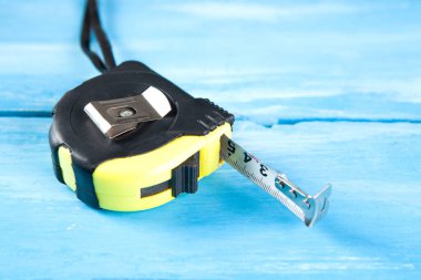 Kendini geri çeken metal şerit mavi ahşap bir masa üzerinde