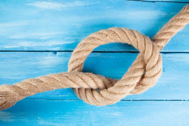 Ahşap bir arka planda kalın bir ip örülmüş.