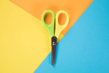 Çok renkli kağıt parçalarının üzerinde makas. kesme aracı