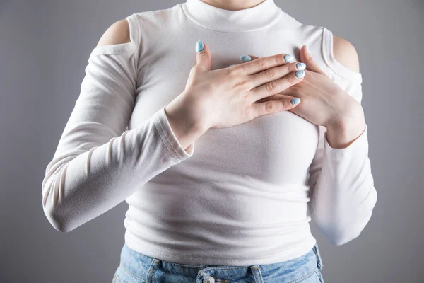 Ung Kvinna Lade Sin Hand Bröstet Grå Bakgrund — Stockfoto