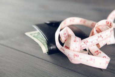 Gri ahşap bir masada bant ve cüzdan ölçüyorum. para miktarı