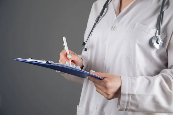 Arts Een Witte Jas Maakt Aantekeningen Een Grijze Achtergrond — Stockfoto