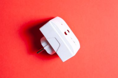 Kırmızı arkaplanda elektrik adaptörü