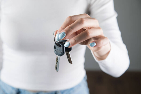 young woman in white holds keys