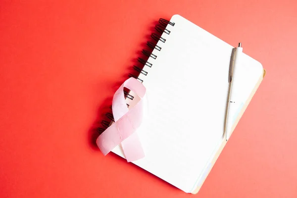 Notepad Pink Ribbon Red Background — Stock Photo, Image
