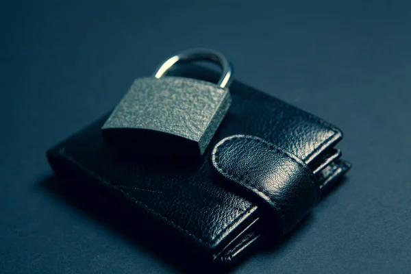 lock on a black wallet. money saving concept on black background