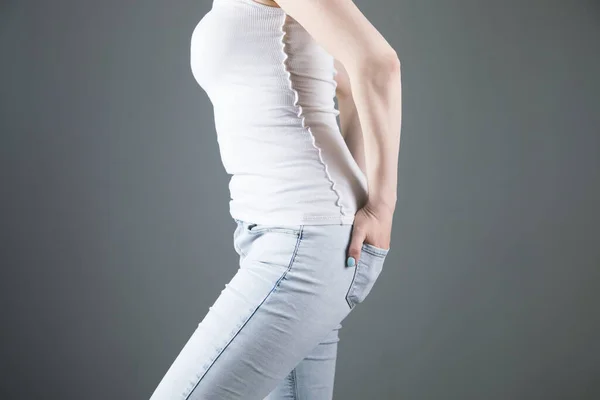 Young Girl Holding Hands Back Pockets Gray Background — Stock Photo, Image