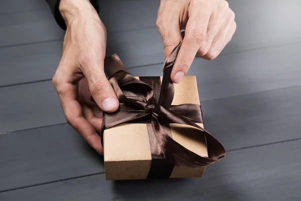 Man Opens Gift Ribbon Gray Wooden Background — Stock Photo, Image