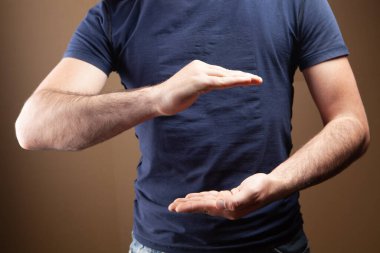 Kahverengi arka planda koruma hareketi gösteren bir adam