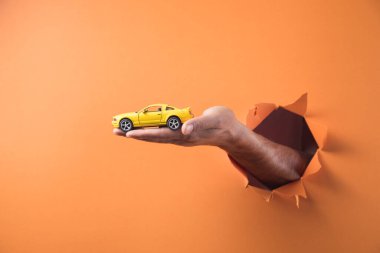 El arabası turuncu arka planda.