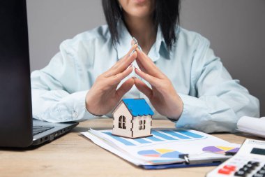 Masasının önündeki iş kadını evi koruyor.