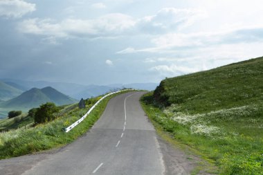Asfalt yol aşağı iniyor dağlık araziye Akşamleyin ormanda