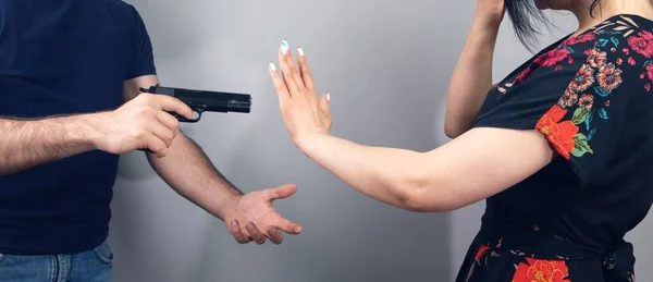 Mann Griff Frau Vor Grauem Hintergrund Mit Pistole — Stockfoto