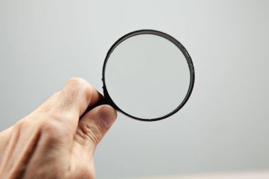 holding a magnifying glass on a gray background. search concept