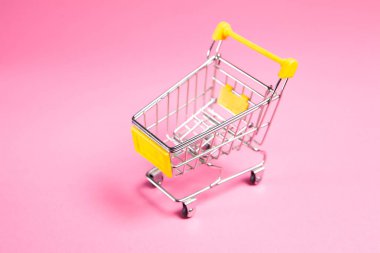 trolley on a pink background. shopping concept