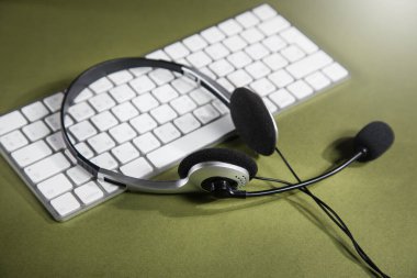 Beyaz bir klavyede kulaklık. destek hizmeti kavramı