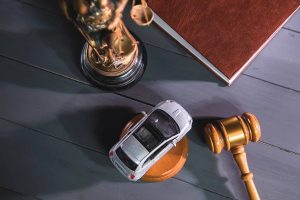 Adalet heykeli, tahta arka planda tokmak ve araba. deneme