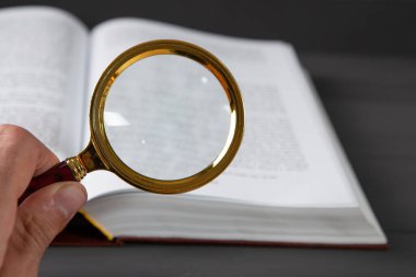 Açık kitap ve büyüteç. Kitapları ara. materyal eğitimi