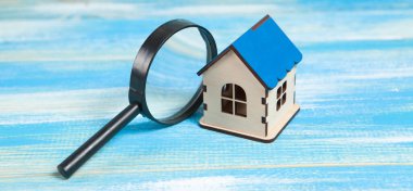 magnifier and house. home search concept. home inspection on a blue table clipart