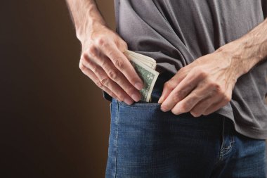 Adam kahverengi arka plana para koyuyor.